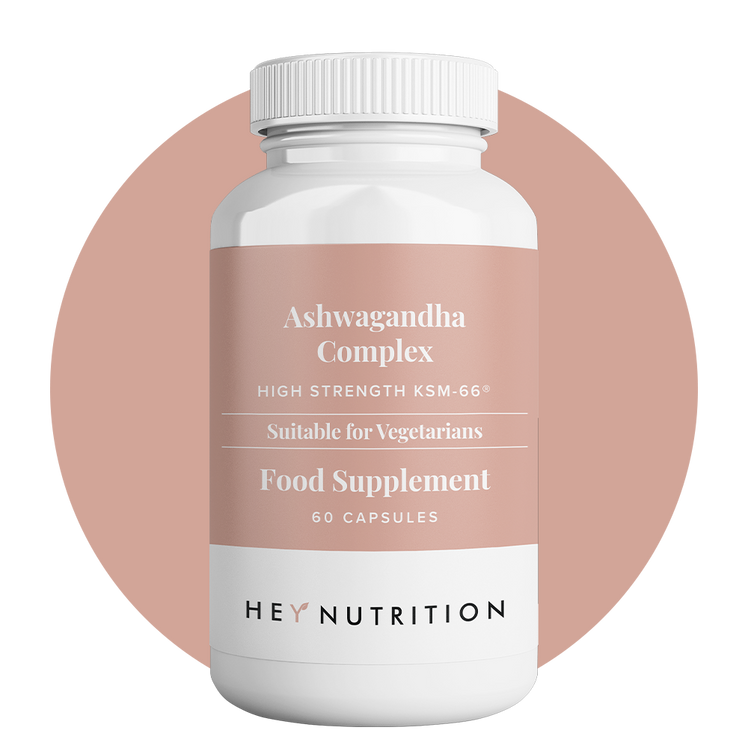 Hey Nutrition Ashwagandha Complex supplement bottle with light pink label on a pink background.