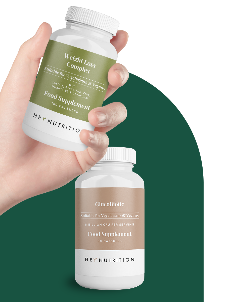 A hand holding a bottle of Hey Nutrition Weight Loss Complex (180 capsules), with a second bottle of GlucoBiotic (30 capsules) shown below. Both bottles highlight suitability for vegetarians and vegans, with clear product names and key benefits labeled, set against a curved dark green background.