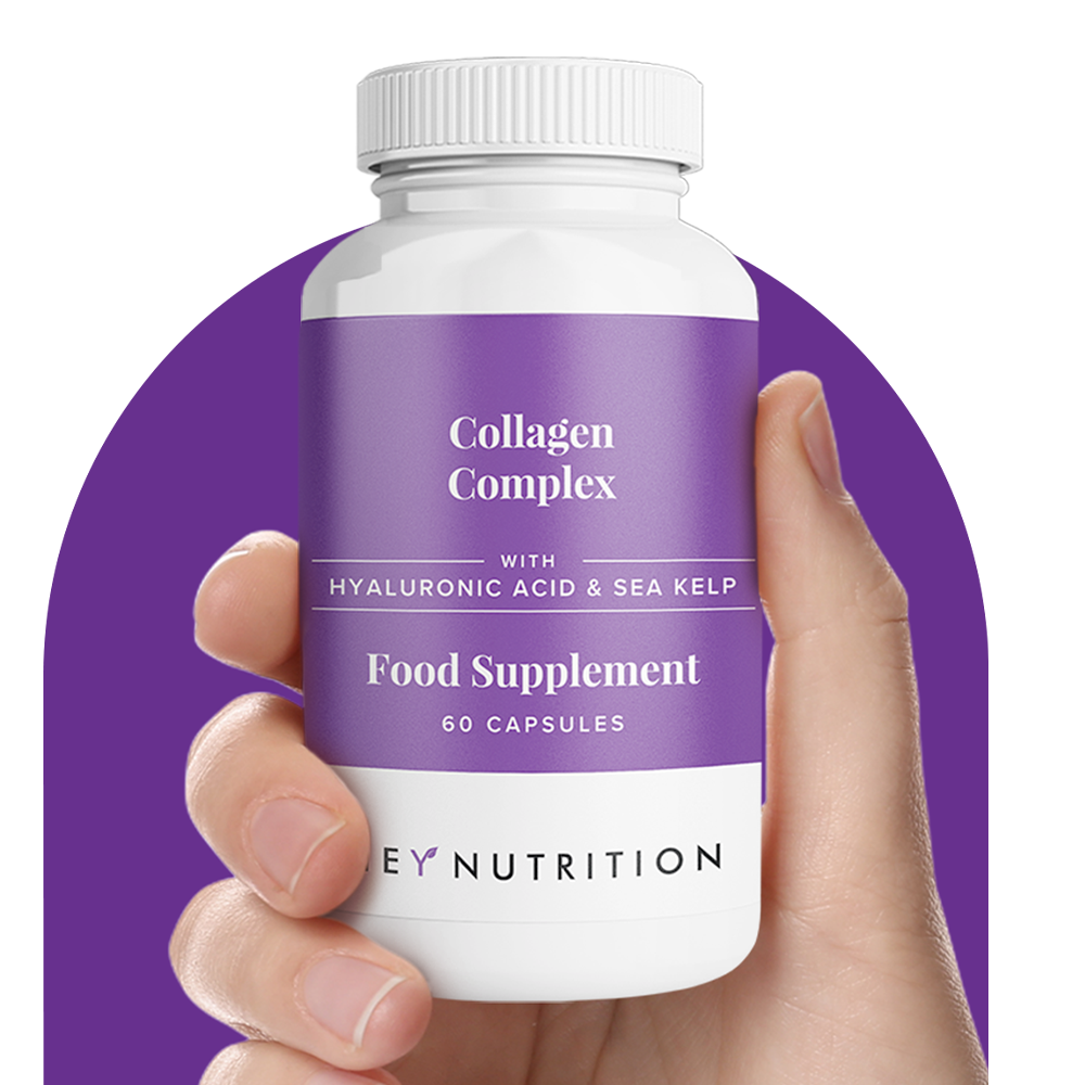 Hand holding Hey Nutrition Collagen Complex bottle, labeled with hyaluronic acid and sea kelp, 60 capsules, on a purple background.